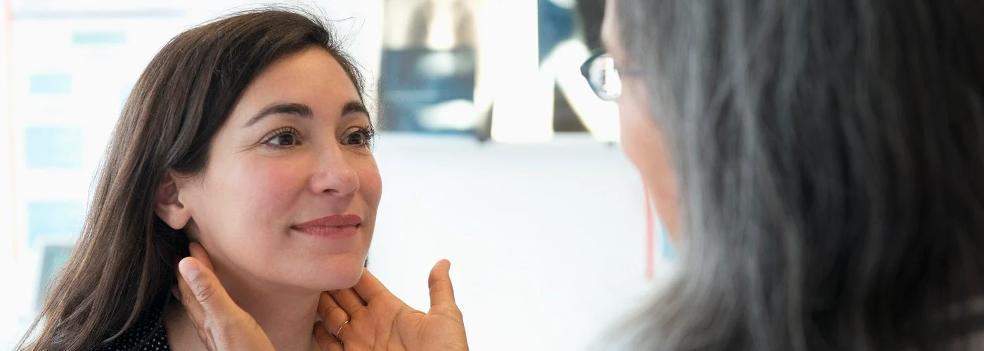 A patient undergoing a thyroid examination with an endocrinologist