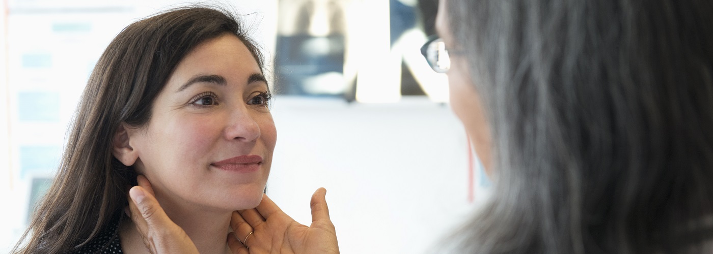 A patient undergoing a thyroid examination with an endocrinologist