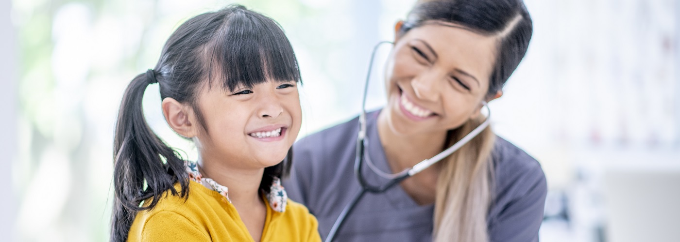 A paediatrician with a young girl during a check-up
