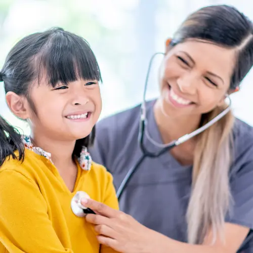 A paediatrician with a young girl during a check-up