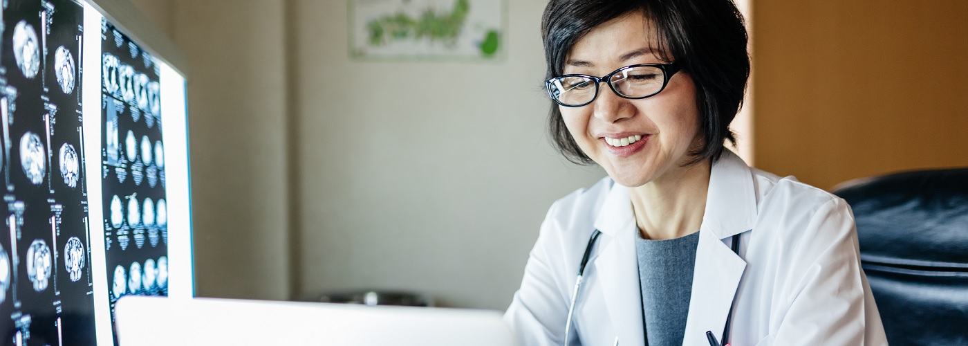 Radiologist analysing medical scans on a computer.