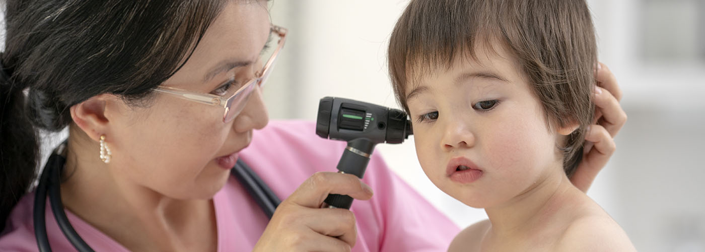 An ENT specialist examining a young child&#39;s ear