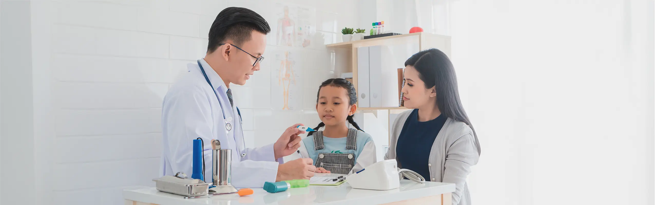 医生与妈妈和女儿讨论小孩发烧的应对方法