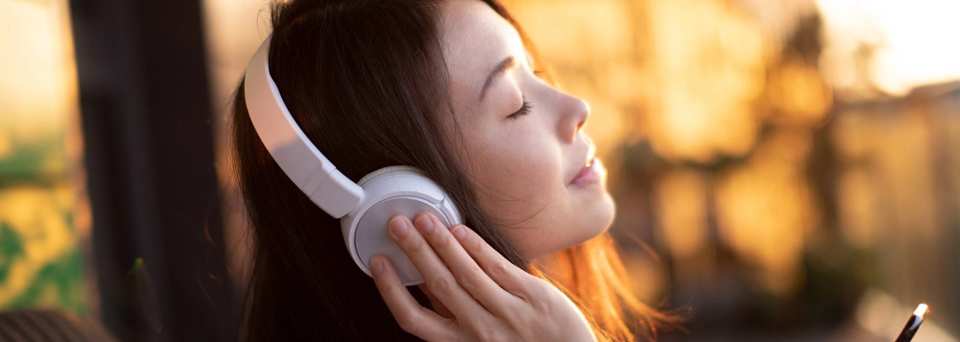Woman enjoying music through her headphone after receiving otology treatment