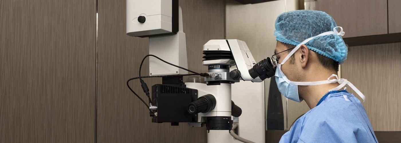 A hand surgeon using a microscope for microsurgical procedures